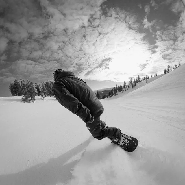 Riding a backcountry line, hand down in the snow
