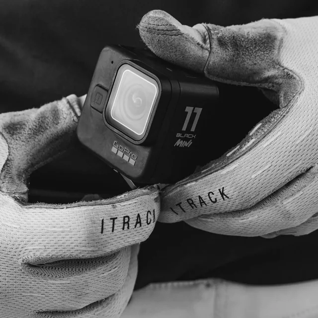 A GoPro Hero 11 Black Mini held in gloved hands